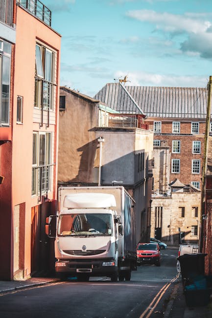 Photograph of a narrow street in Harlington with tightly packed, traditional terraced houses constructed from stone and brick, featuring small sash windows and pitched tiled roofs. Some buildings are
